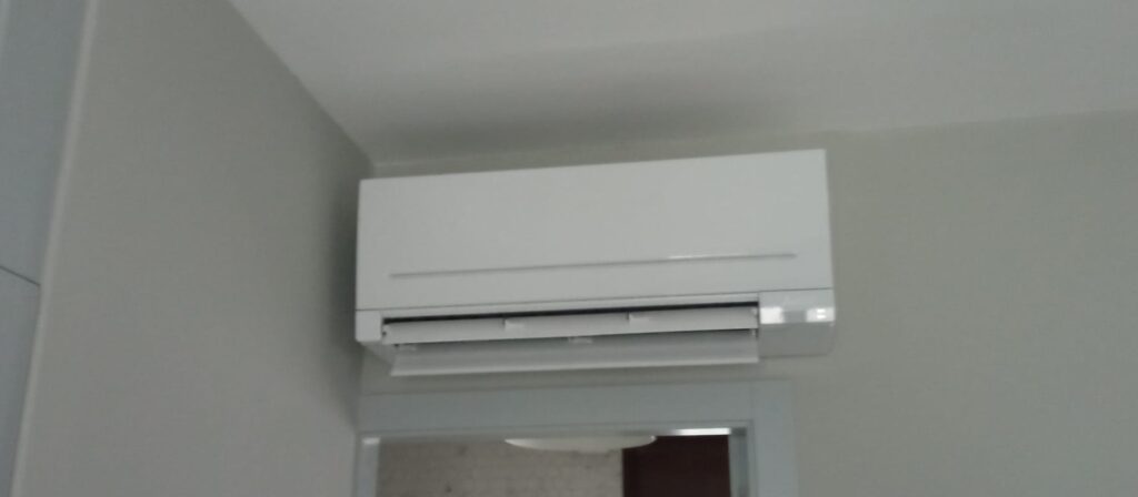 Aire acondicionado split instalado sobre puerta de dormitorio en vivienda de Pontevedra.